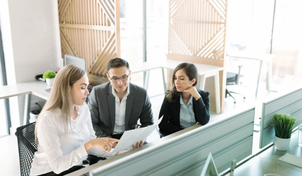 group of lawyers in professional attire looking a documents togther