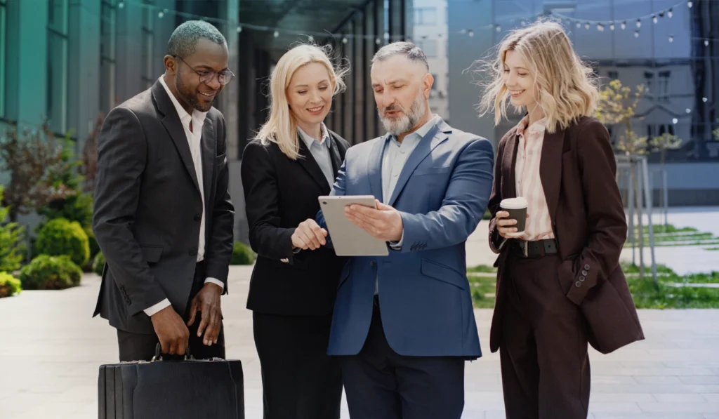 Group of lawyers dressed professionally looking at a document together outside of office building